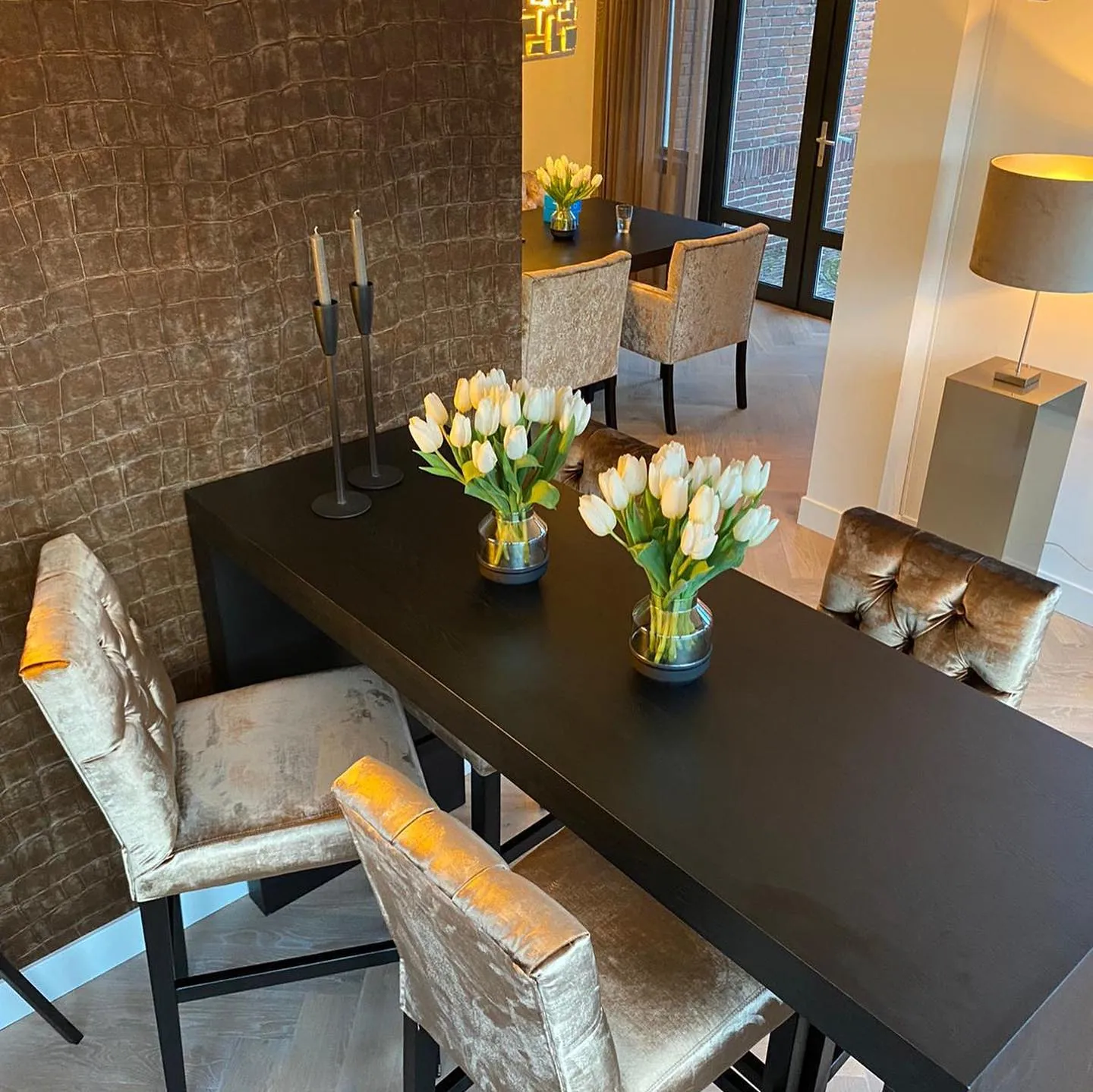 Bartafel met stoelen en tulpen tegen een structuurwand