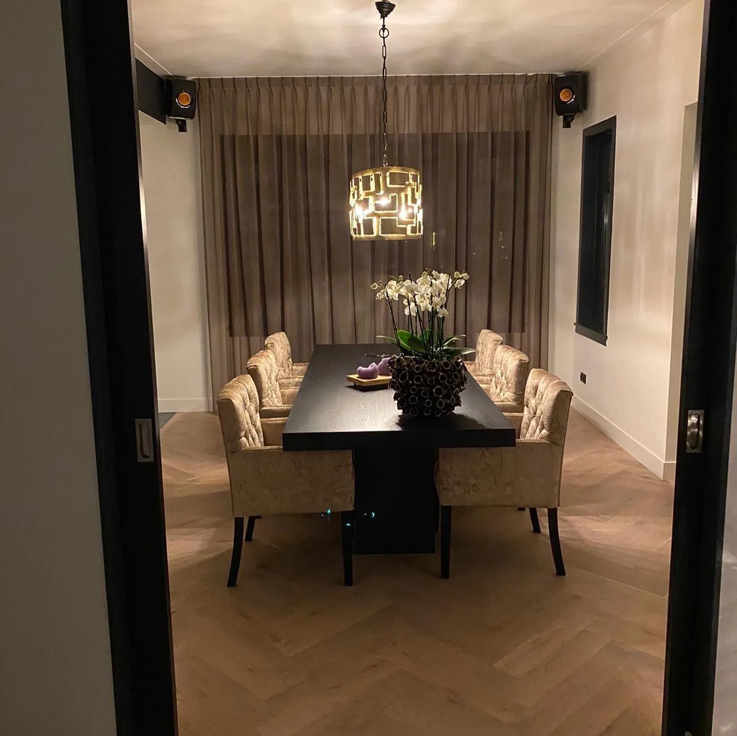 Eetkamer met lange donkere eettafel en gecapitonneerde stoelen