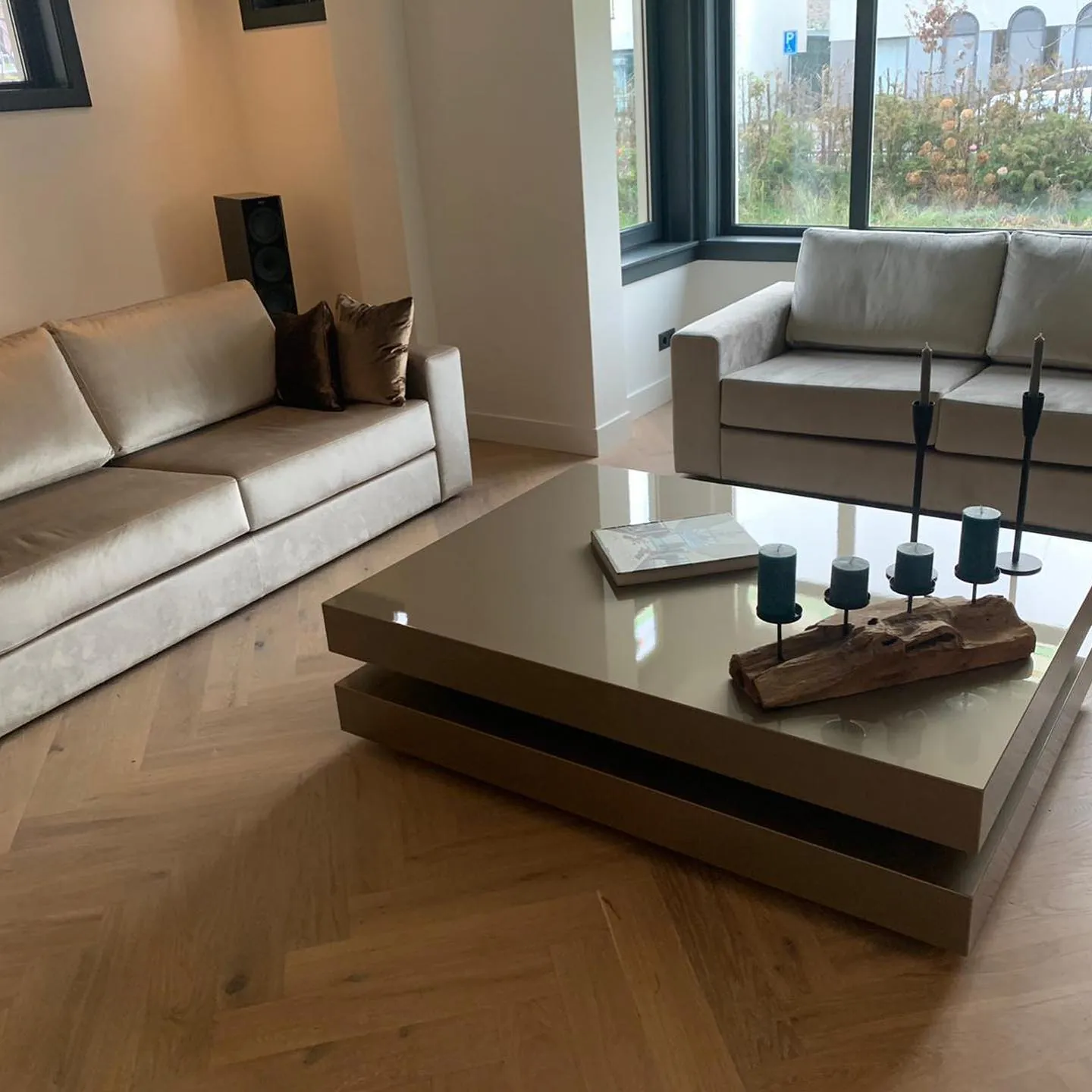 Woonkamer met lichte banken en een glanzende salontafel